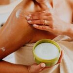 mujer con crema en el hombro