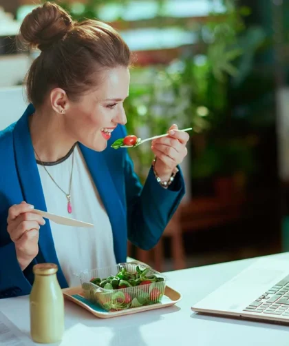 mujer en oficina comiendo